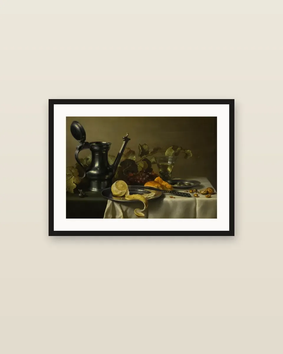 Still life with a 'Jan Steen' jug, a peeled lemon on a pewter plate, bread, olives, grapes, a glass and nuts by Pieter Claesz., framed