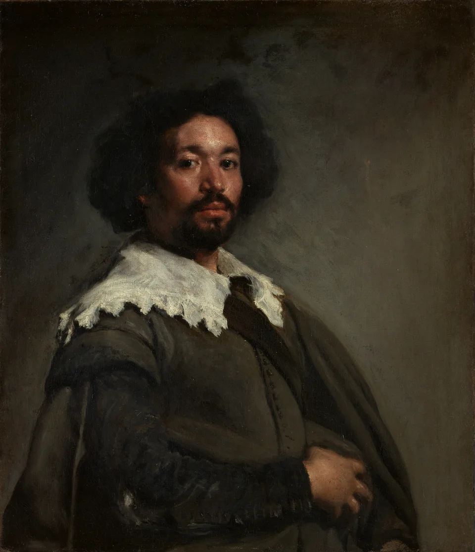 A half-length portrait of a man in a plain dark cloak with a broad white lace collar, turned slightly to one side and looking directly out of the picture against a grey background.