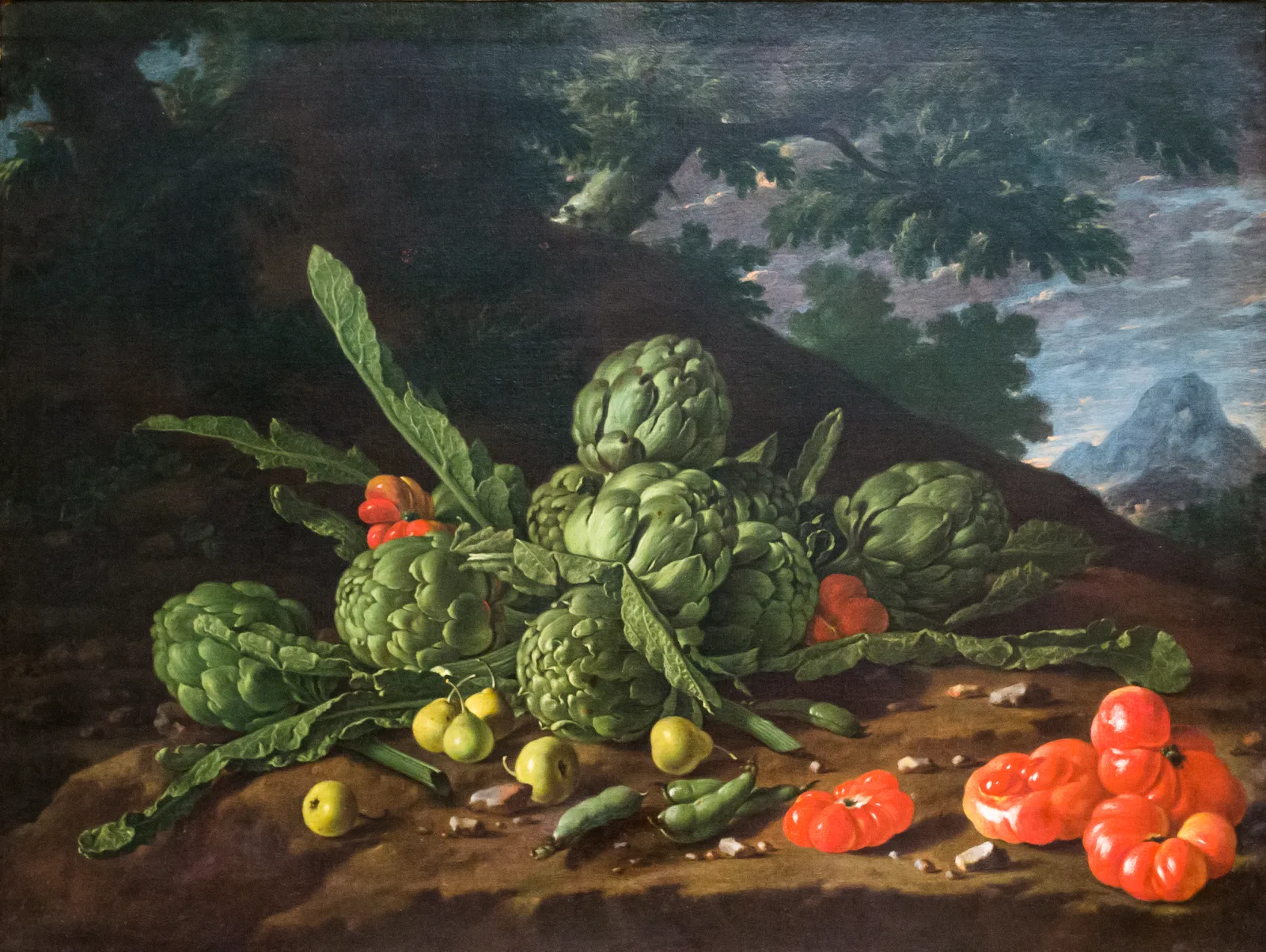 A pile of artichokes with pea pods, small pears and red tomatoes lies on the ground before dark trees, with a small hilly landscape beyond to the right.